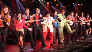 Full cast of comedy jamboree in a kick line